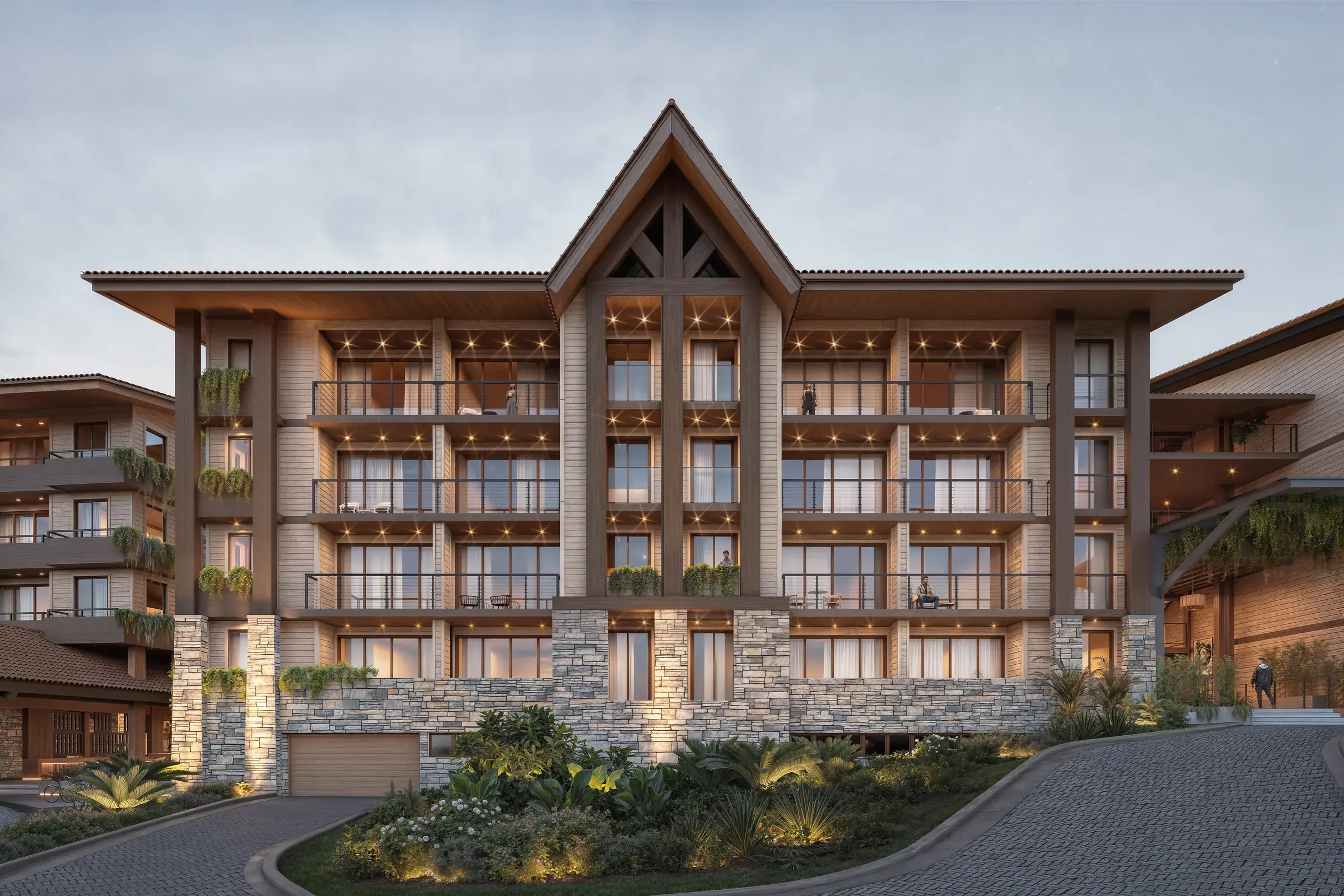 Architectural render of the Pinoalto Condo Suites main facade at dusk, a timber-and-stone building with a central gabled entrance, tile roofs and balconies on every floor.