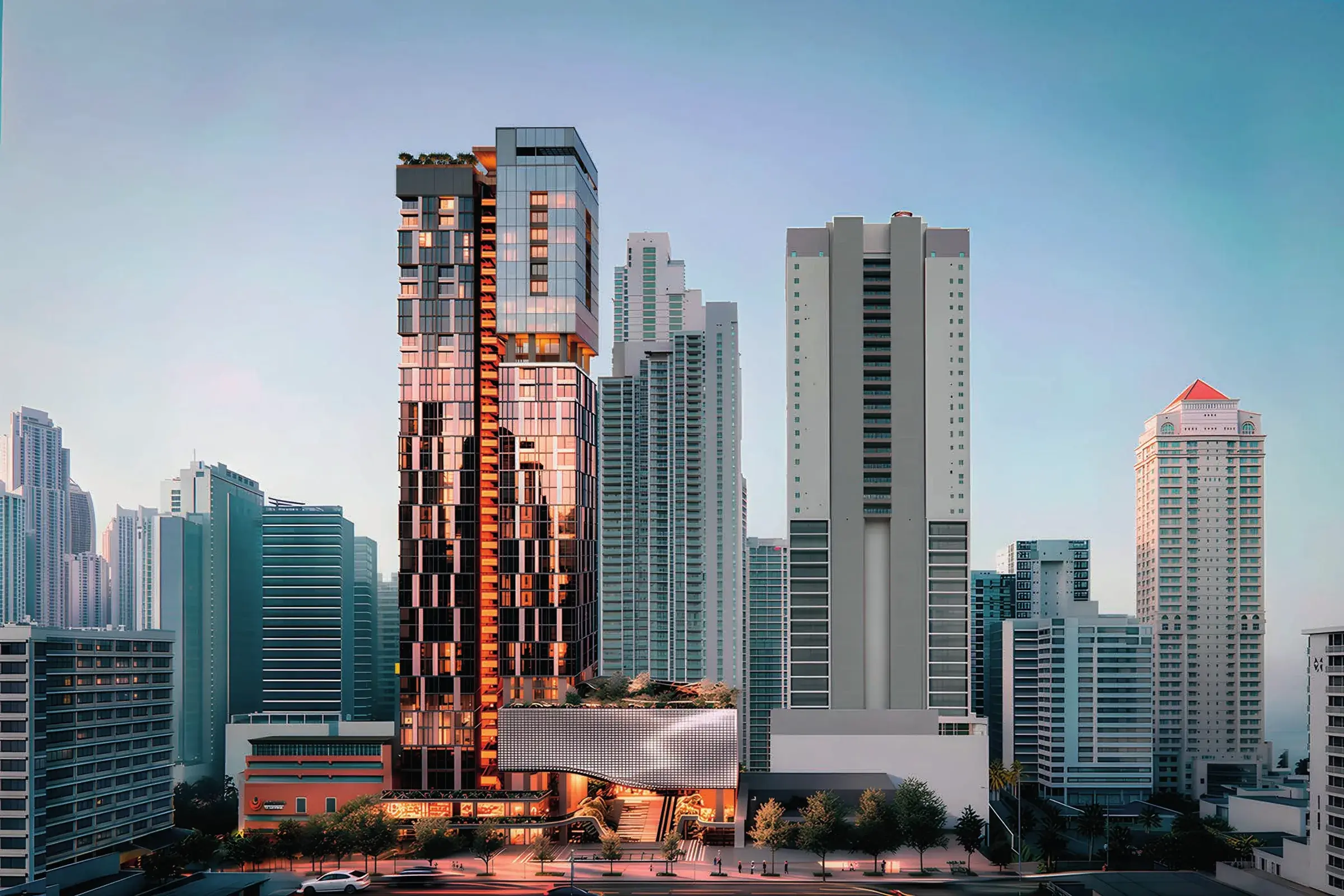 Architectural render of the Uptown Condo Suites tower at dusk among Bella Vista high-rises, with a dark glazed shaft, an orange stair-lit spine and a silver podium at street level.